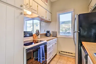 a kitchen with white cabinets and a black refrigerator at 4 Mi to Keystone Resort Dillon Condo with Patio in Dillon