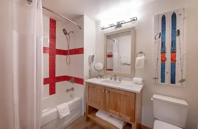 a bathroom with a tub and a sink and a toilet at Zephyr Mountain Lodge Premium-Rated 2416 in Winter Park
