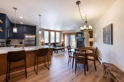 a kitchen and living room with a table and chairs at Zephyr Mountain Lodge Premium-Rated 2416 in Winter Park