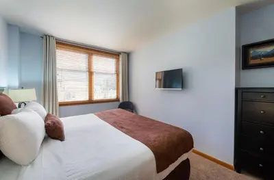 a bedroom with a large bed and a window at Zephyr Mountain Lodge Premium-Rated 2416 in Winter Park