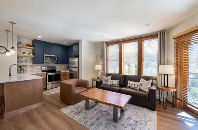 a kitchen and living room with a couch and a table at Zephyr Mountain Lodge Premium-Rated 2416 in Winter Park