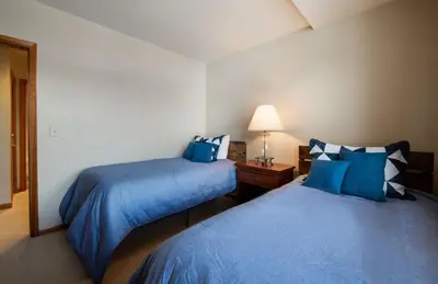 two beds in a hotel room with blue pillows at Zephyr Mountain Lodge Value-Rated 2508 in Winter Park