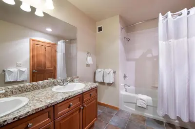 a bathroom with two sinks and a shower and a tub at Zephyr Mountain Lodge Value-Rated 2508 in Winter Park