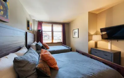 a bedroom with two beds and a flat screen tv at Zephyr Mountain Lodge Select-Rated 2510 in Winter Park