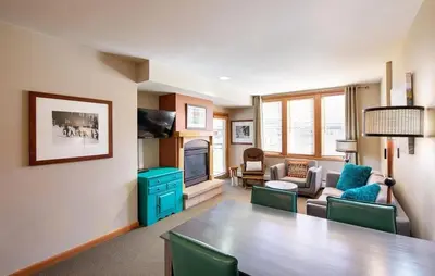 a living room with a dining table and a living room with a couch at Zephyr Mountain Lodge Select-Rated 2510 in Winter Park