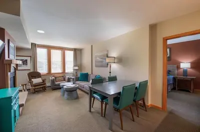 a living room with a table and green chairs at Zephyr Mountain Lodge Select-Rated 2510 in Winter Park