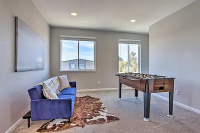 a game room with a blue couch and a table at 6 Mi to Dtwn Denver Townhome with Patio! in Thornton