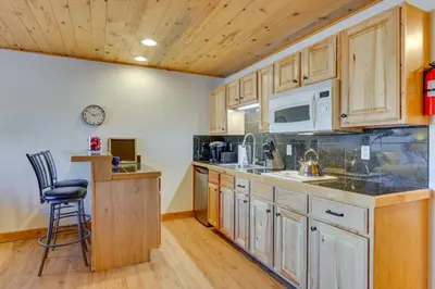 a kitchen with wooden cabinets and a counter top at Near Skiing Studio with Pool Access in Granby! in Granby
