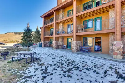 a building with benches in front of it in the snow at Near Skiing Studio with Pool Access in Granby! in Granby