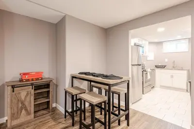 a kitchen with a counter and stools and a refrigerator at Cottonwood Loveland in Loveland