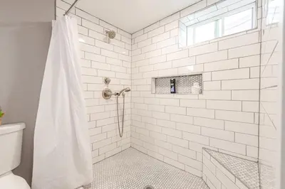 a white bathroom with a shower and a toilet at Cottonwood Loveland in Loveland