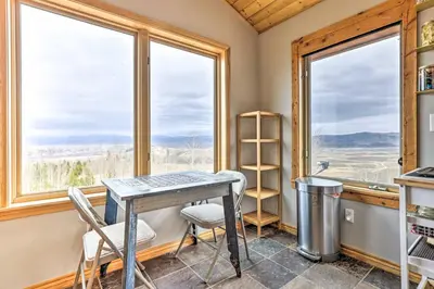 a kitchen with a table and two chairs and windows at Secluded Granby Mtn Cabin 75 Acres and Views in Granby