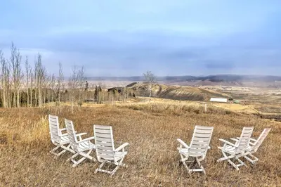 a group of white chairs sitting in a field at Secluded Granby Mtn Cabin 75 Acres and Views in Granby