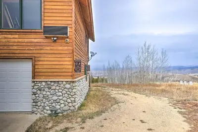 a building with a garage next to a dirt road at Secluded Granby Mtn Cabin 75 Acres and Views in Granby