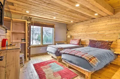 a bedroom with two beds in a log cabin at Secluded Granby Mtn Cabin 75 Acres and Views in Granby