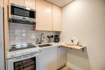 a kitchen with a stove and a sink and a microwave at Cedar Lodge Royal Studio Condo: Downtown Frisco in Frisco
