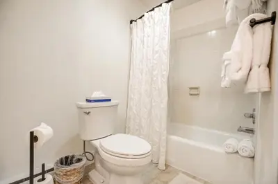 a white bathroom with a toilet and a shower at Cedar Lodge Royal Studio Condo: Downtown Frisco in Frisco