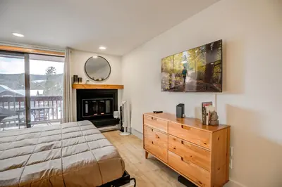 a bedroom with a bed and a fireplace and a mirror at Cedar Lodge Royal Studio Condo: Downtown Frisco in Frisco