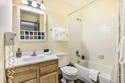 a bathroom with a sink and a toilet and a tub at Winter Park Condo with Hot Tub, 3 Mi to Slopes! in Winter Park