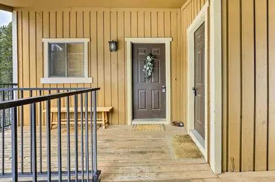 a house with a door and a bench on a porch at Winter Park Condo with Hot Tub, 3 Mi to Slopes! in Winter Park