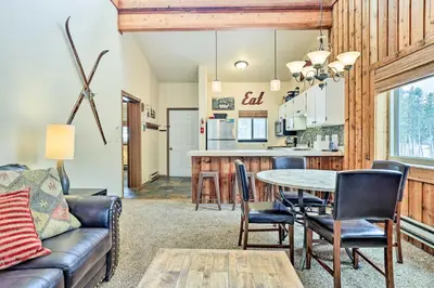 a living room with a couch and a table at Winter Park Condo with Hot Tub, 3 Mi to Slopes! in Winter Park
