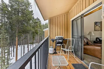 a screened in porch with a grill on a deck at Winter Park Condo with Hot Tub, 3 Mi to Slopes! in Winter Park