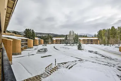 a snow covered street in front of a building at Winter Park Condo with Hot Tub, 3 Mi to Slopes! in Winter Park
