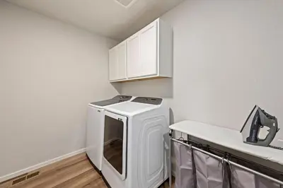 a white laundry room with a washer and dryer at Hidden Gem - Brand New Curated Home with Pool Access in Fort Collins