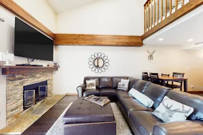 a living room with a leather couch and a fireplace at Mountainside Retreat in Frisco