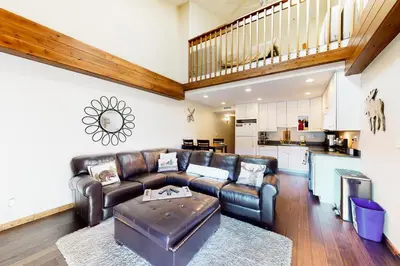 a living room with a leather couch and a kitchen at Mountainside Retreat in Frisco