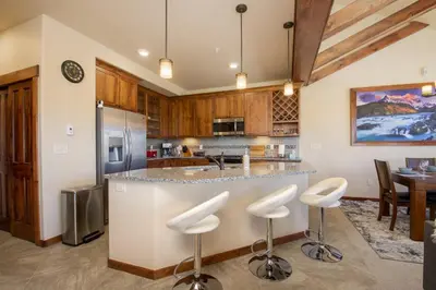 a kitchen with a bar with stools in it at Byers Peak Penthouse in Fraser