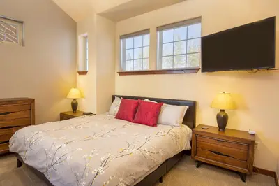 a bedroom with a bed and a flat screen tv at Byers Peak Penthouse in Fraser