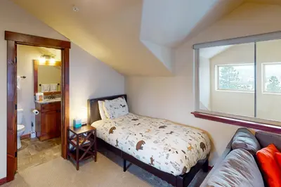 a bedroom with a bed and a couch and a window at Byers Peak Penthouse in Fraser