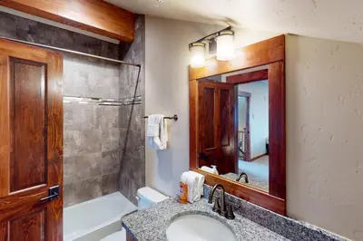 a bathroom with a sink and a shower and a mirror at Byers Peak Penthouse in Fraser