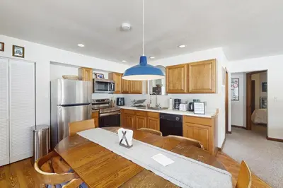 a kitchen with a wooden table and a refrigerator at Skiing Sanctuary in Winter Park