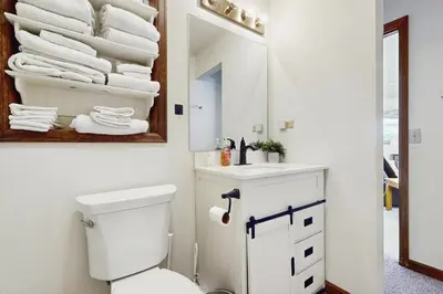 a bathroom with a toilet and a mirror and towels at Skiing Sanctuary in Winter Park