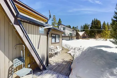a deck with chairs and a house in the snow at Skiing Sanctuary in Winter Park