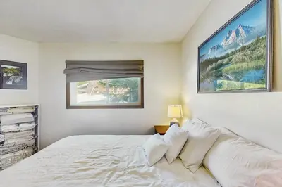 a bedroom with a white bed with a window at Skiing Sanctuary in Winter Park