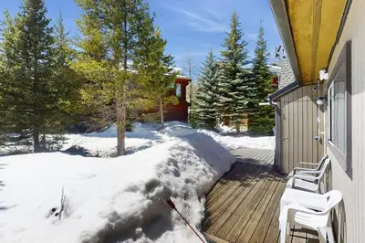 a wooden deck with two chairs on it in the snow at Skiing Sanctuary in Winter Park