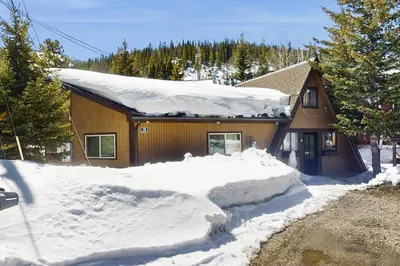 a house with a pile of snow in front of it at Skiing Sanctuary in Winter Park