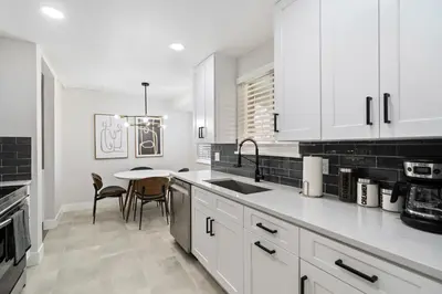 a kitchen with white cabinets and a table with chairs at #Marbella Lane - Modern & Spacious 4BR Retreat in Arvada in Arvada
