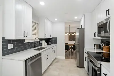 a white kitchen with a sink and a refrigerator at #Marbella Lane - Modern & Spacious 4BR Retreat in Arvada in Arvada