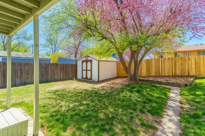 a backyard with a tree and a fence at #Marbella Lane - Modern & Spacious 4BR Retreat in Arvada in Arvada