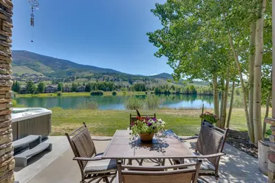 a table and chairs with a view of a lake at Stunning Mtn Views and Hot Tub Silverthorne Retreat in Silverthorne