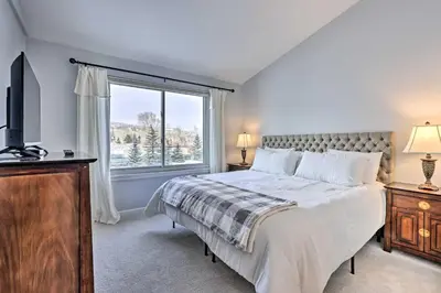 a bedroom with a bed and a large window at Stunning Mtn Views and Hot Tub Silverthorne Retreat in Silverthorne