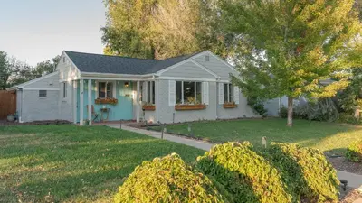 a small white house with a yard at Comfy w King Bed Bring pup & walk 2 Everything in Arvada