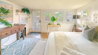 a bedroom with a bed and a table and windows at Comfy w King Bed Bring pup & walk 2 Everything in Arvada