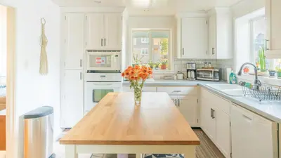a kitchen with a table with a vase of flowers on it at Comfy w King Bed Bring pup & walk 2 Everything in Arvada