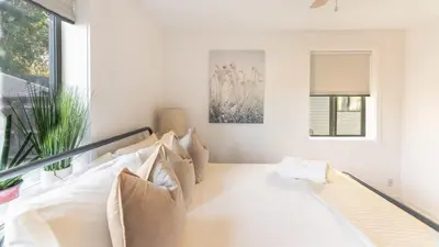 a white living room with a couch and a window at Comfy w King Bed Bring pup & walk 2 Everything in Arvada