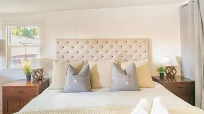 a white bedroom with a large bed with pillows at Comfy w King Bed Bring pup & walk 2 Everything in Arvada